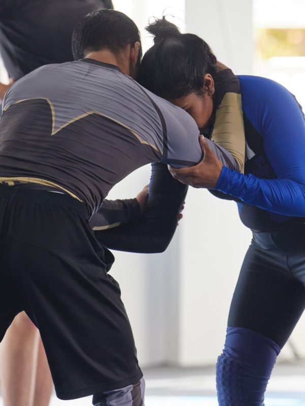 Cropped shot of a jiu jitsu sensei sparring with one of his students during a class.